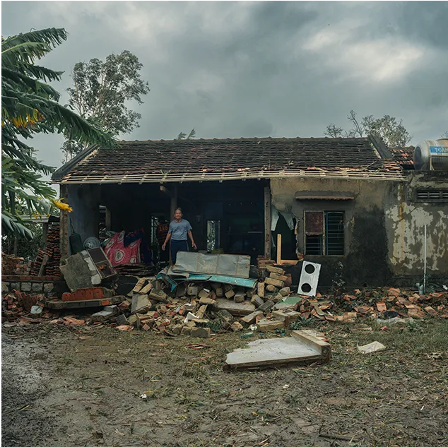 Casa destruída e moradores em meio aos escombros após a enchente