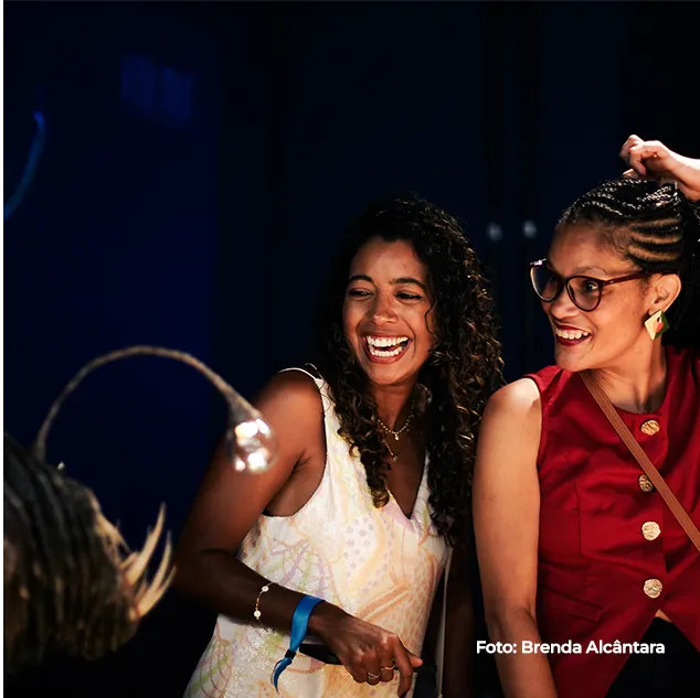 Duas jovens sorriem durante a visita à exposição